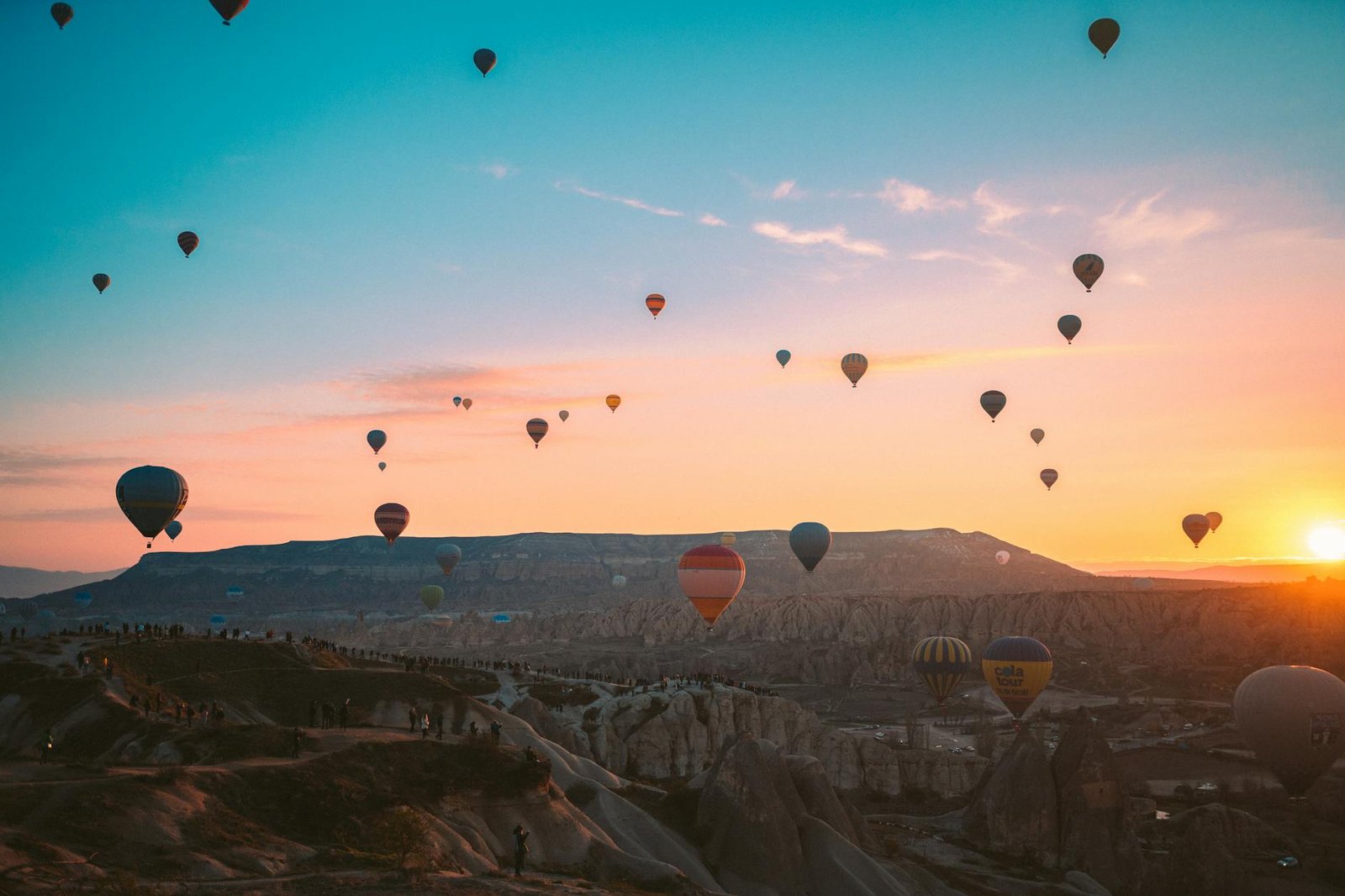 hot air balloons flying over the mountains